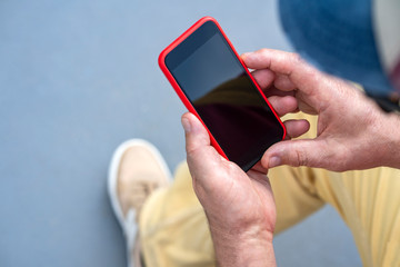 one old man of European nationality takes pictures of interesting places, uses a smartphone, a view from the back, bright clothes and a backpack on his back, horizontal shot close-up,  day,