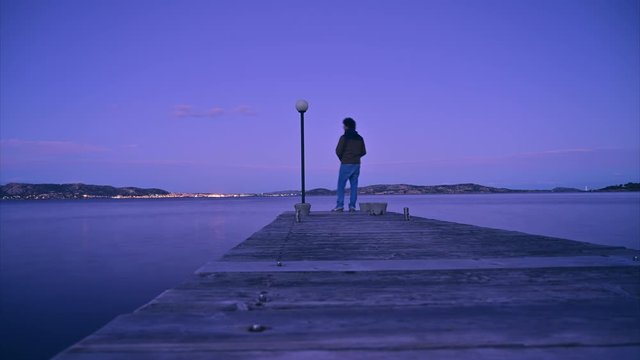 timelapse hyperlapse of anonymous fisherman spinning eging catching squid octopus cuttlefish at sunset star night sky