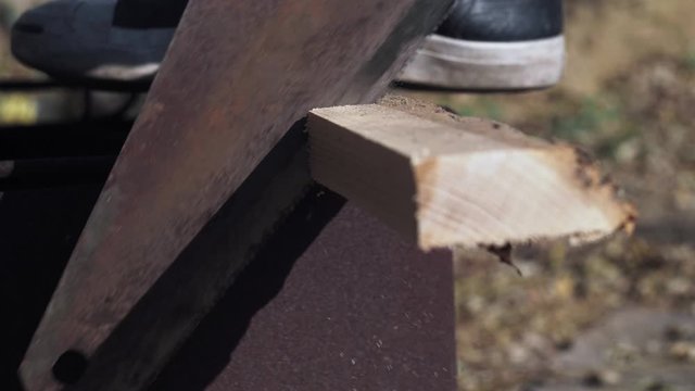 closeup man saws firewood hand saw. male hand sawing old wood. 4k video. 59.94 fps