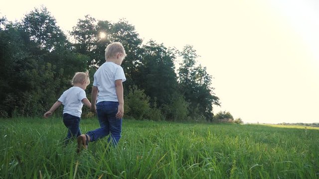 Happy family walking: funny slow motion video little kid boy hold hands go nature play whirl a and girl brother and sister hold hand on nature happy children concept. children happy lifestyle family