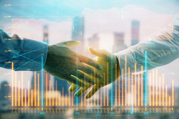 Double exposure of financial graph on cityscape background with two businessman handshake. Concept of stock market deal