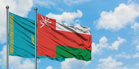 Kazakhstan and Oman flag waving in the wind against white cloudy blue sky together. Diplomacy concept, international relations.