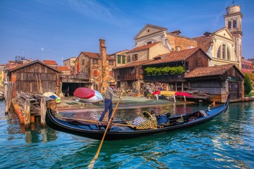 Gondola with tourist in front of Squero di San Tommaso. © StockPhotoAstur