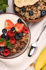 Tasty homemade granola served on table. Healthy breakfast with a bowl of oatmeal with banana, blueberries, strawberries and healthy food for Breakfast