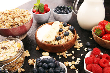 Tasty homemade granola served on table. Healthy breakfast with a bowl of oatmeal with banana, blueberries, strawberries and healthy food for Breakfast