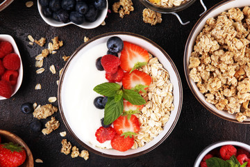 Tasty homemade granola served on table. Healthy breakfast with a bowl of oatmeal with banana, blueberries, strawberries and healthy food for Breakfast