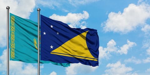 Kazakhstan and Tokelau flag waving in the wind against white cloudy blue sky together. Diplomacy concept, international relations.