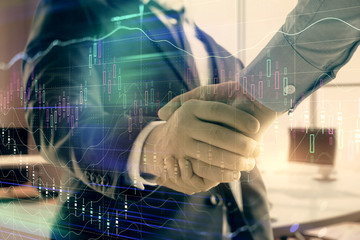 Multi exposure of financial graph on office background with two businessmen handshake. Concept of success in business