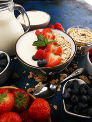 Tasty homemade granola served on table. Healthy breakfast with a bowl of oatmeal with banana, blueberries, strawberries and healthy food for Breakfast