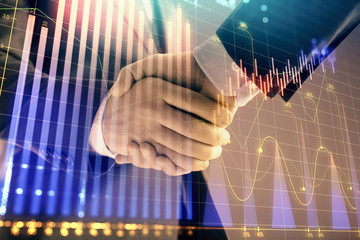 Multi exposure of forex graph on abstract background with two businessmen handshake. Concept of success on stock market