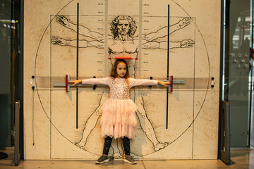 Little girl on the background of the Vitruvian man. The concept of body proportions