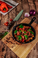 Cast iron frying pan with vegetables on a desk in