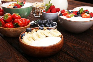Tasty homemade granola served on table. Healthy breakfast with a bowl of oatmeal with banana, blueberries, strawberries and healthy food for Breakfast