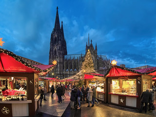 Cologne Cathedral Christmas Market in twilight, Germany. This is the most popular and best-known of all the city markets in front of the famous Cologne Cathedral. - obrazy, fototapety, plakaty