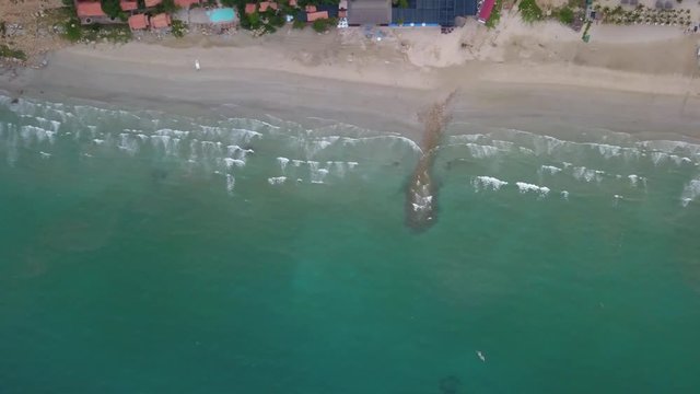 A flying camera captures a sea wave on a sandy beach in Vietnam.