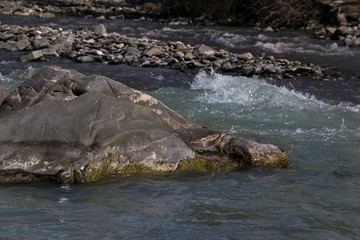 Mountain fast river and stone on the shore, background, Caucasus