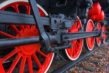 Fragment of a retro locomotive on railway,red wheels of the black locomotive 