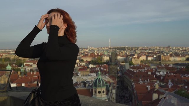 Happy readhead woman start fresh new life looking at Prague centre and Charles Bridge view from above - Professional stabilized shot - Czech Republic