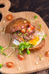 Burger with cherry tomato, green sprout and fried egg