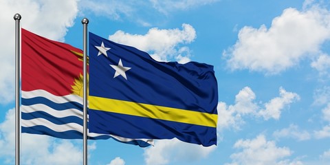 Kiribati and Curacao flag waving in the wind against white cloudy blue sky together. Diplomacy concept, international relations.