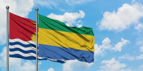 Kiribati and Gabon flag waving in the wind against white cloudy blue sky together. Diplomacy...