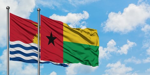 Kiribati and Guinea Bissau flag waving in the wind against white cloudy blue sky together. Diplomacy concept, international relations.