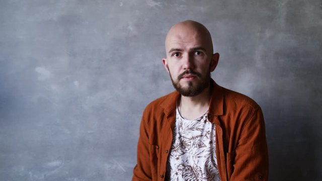 portrait of a bald bearded young man in a shirt