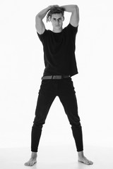 Black and White Muscle strong beautiful stripped male model in denim jeans and black t-shirt with belt on white isolated font background