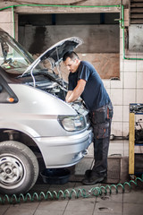 Car mechanic repairer service technician checks and repairs auto engine