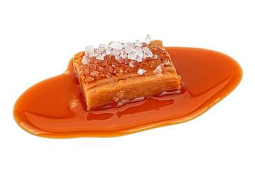 Delicious candy with salt and caramel sauce isolated on white background