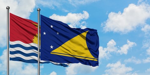 Kiribati and Tokelau flag waving in the wind against white cloudy blue sky together. Diplomacy concept, international relations.