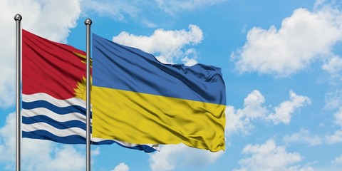 Kiribati and Ukraine flag waving in the wind against white cloudy blue sky together. Diplomacy concept, international relations.