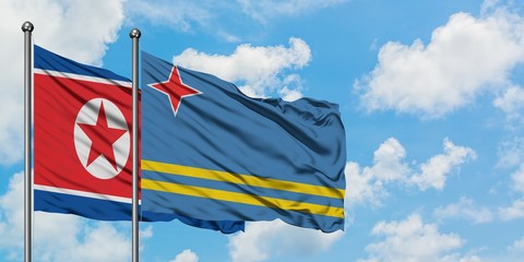 North Korea and Aruba flag waving in the wind against white cloudy blue sky together. Diplomacy concept, international relations.
