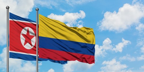 North Korea and Colombia flag waving in the wind against white cloudy blue sky together. Diplomacy concept, international relations.