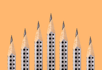 graphite pencils with the fine tip on an ocher background