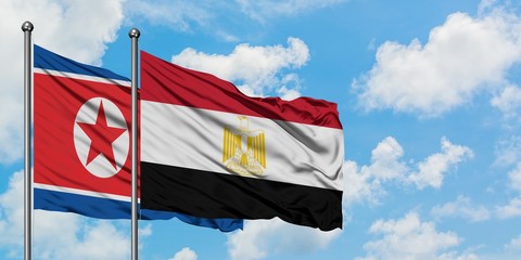 North Korea and Egypt flag waving in the wind against white cloudy blue sky together. Diplomacy concept, international relations.