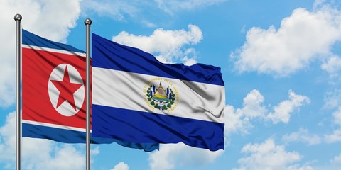 North Korea and El Salvador flag waving in the wind against white cloudy blue sky together. Diplomacy concept, international relations.