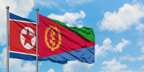 North Korea and Eritrea flag waving in the wind against white cloudy blue sky together. Diplomacy concept, international relations.