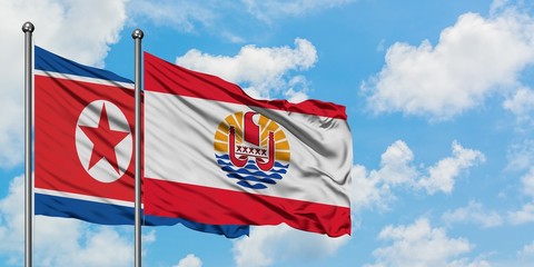 North Korea and French Polynesia flag waving in the wind against white cloudy blue sky together. Diplomacy concept, international relations.