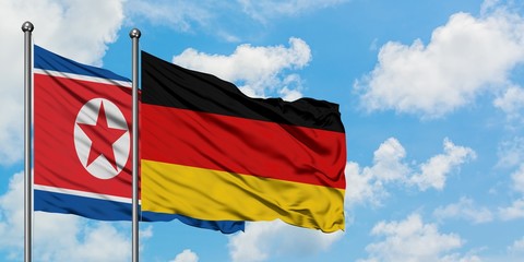North Korea and Germany flag waving in the wind against white cloudy blue sky together. Diplomacy concept, international relations.