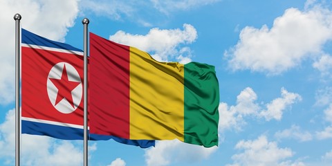 North Korea and Guinea flag waving in the wind against white cloudy blue sky together. Diplomacy concept, international relations.