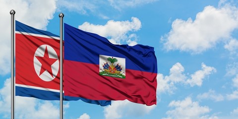 North Korea and Haiti flag waving in the wind against white cloudy blue sky together. Diplomacy concept, international relations.