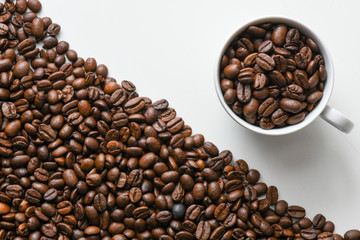 White cup with coffee beans on the background of coffee beans