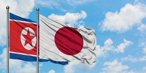 North Korea and Japan flag waving in the wind against white cloudy blue sky together. Diplomacy concept, international relations.