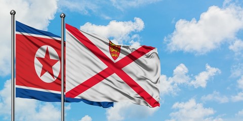 North Korea and Jersey flag waving in the wind against white cloudy blue sky together. Diplomacy concept, international relations.