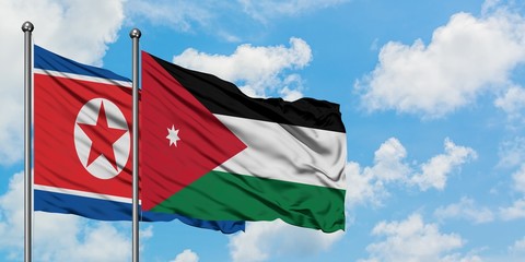North Korea and Jordan flag waving in the wind against white cloudy blue sky together. Diplomacy concept, international relations.