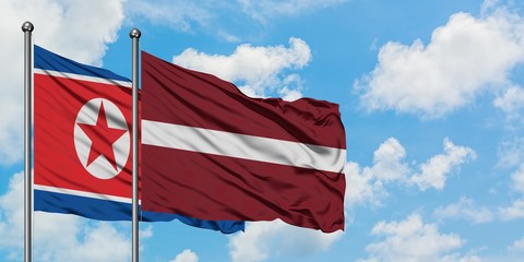 North Korea and Latvia flag waving in the wind against white cloudy blue sky together. Diplomacy concept, international relations.