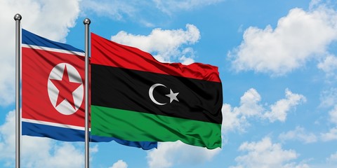 North Korea and Libya flag waving in the wind against white cloudy blue sky together. Diplomacy concept, international relations.