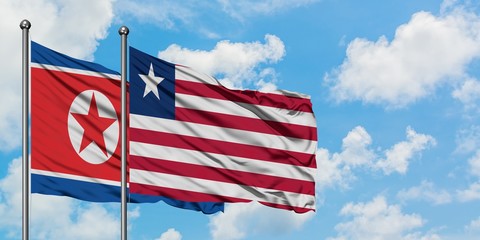 North Korea and Liberia flag waving in the wind against white cloudy blue sky together. Diplomacy concept, international relations.