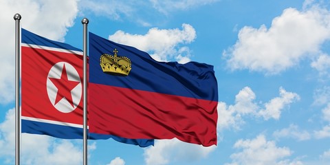 North Korea and Liechtenstein flag waving in the wind against white cloudy blue sky together. Diplomacy concept, international relations.